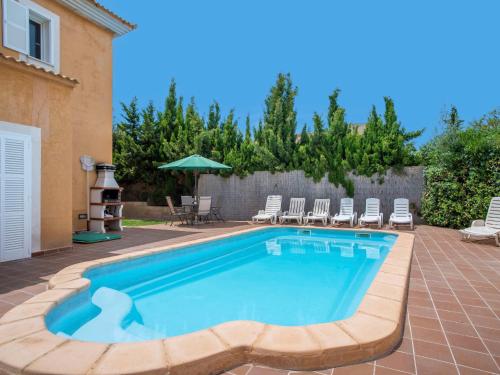 una piscina en un patio con sillas y sombrilla en Holiday Home Sa Coma by Interhome, en Sa Coma