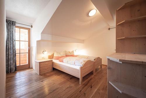 a bedroom with a bed and a window at Kofler zw den Wänden Apt Edelweiss in Campo Tures