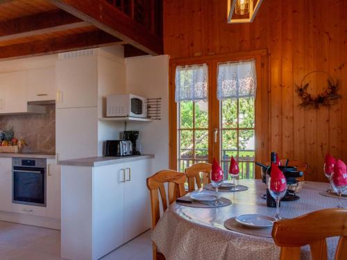 uma cozinha com uma mesa com cadeiras e uma cozinha com uma mesa; em Chalet Anusach by Interhome em Nendaz