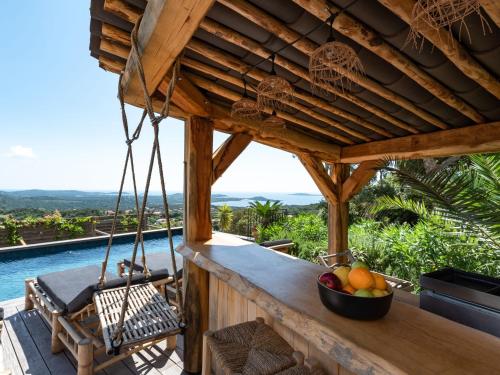 un porche en bois avec un bol de fruits dessus dans l'établissement Villa Villa Casaben by Interhome, à Porto-Vecchio