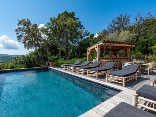 une piscine avec des chaises longues et un gazebo dans l'établissement Villa Villa Casaben by Interhome, à Porto-Vecchio