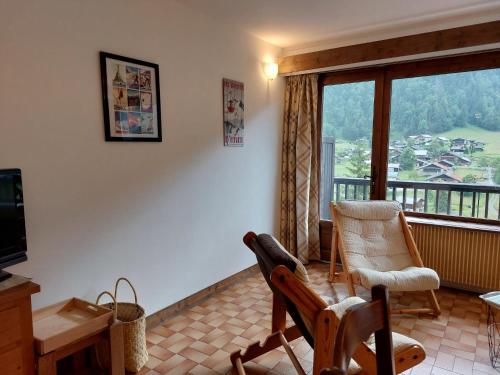 - un salon avec des chaises et une grande fenêtre dans l'établissement Studio Le Bionnassay by Interhome, aux Contamines-Montjoie