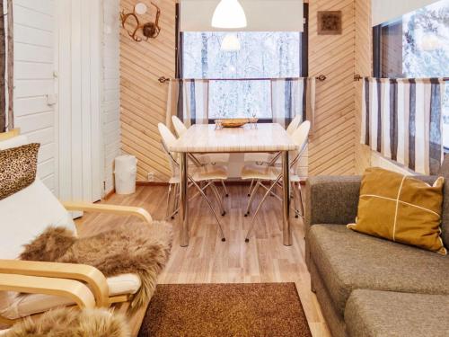 ein Wohnzimmer mit einem Tisch und einem Sofa in der Unterkunft Holiday Home Mustalampi 3 lintukoto by Interhome in Niskala
