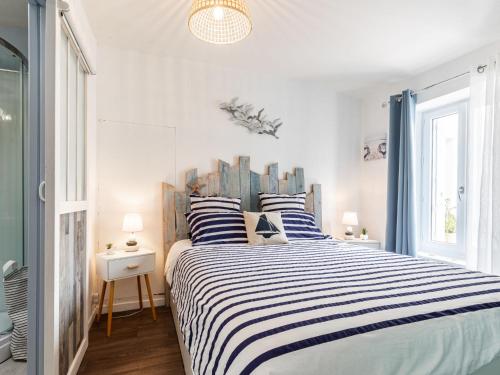 - une chambre avec un grand lit et des oreillers rayés dans l'établissement Holiday Home Les Rosiers by Interhome, à Arvert