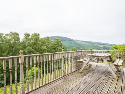 a wooden deck with a picnic table on a fence at Holiday Home Achmony Type 1-1 by Interhome in Drumnadrochit