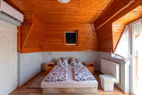 1 dormitorio con 2 camas en una habitación con techos de madera en Kovács Vendégház en Vonyarcvashegy