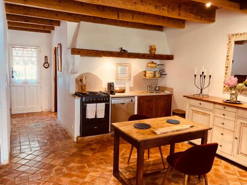 une cuisine avec une table et une cuisinière four supérieur dans l'établissement Mas Antonine, Grenouille, à Arles