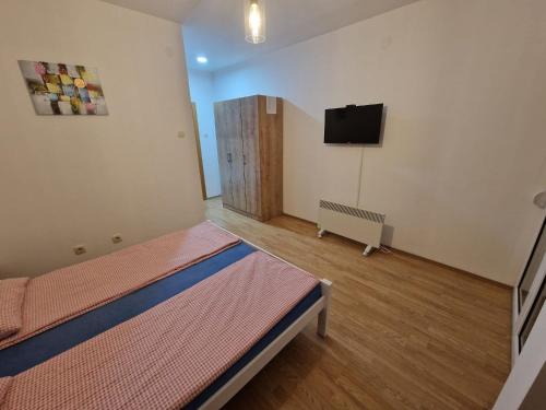 a room with two beds and a flat screen tv at Sobe OLGA in Čačak