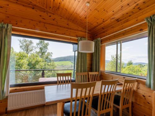 a dining room with a table and chairs and a large window at Holiday Home Achmony Number 6 by Interhome in Drumnadrochit