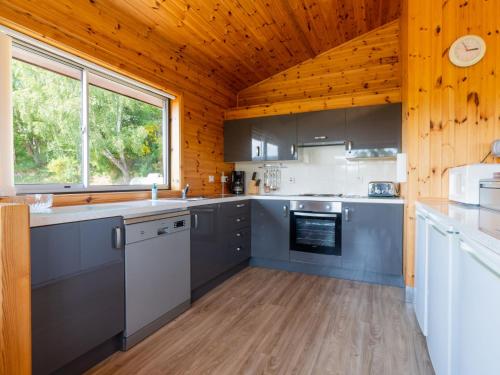 a kitchen with wooden ceilings and a large window at Holiday Home Achmony Number 6 by Interhome in Drumnadrochit