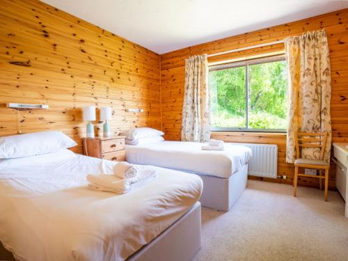 a bedroom with two beds and a window at Holiday Home Achmony Number 6 by Interhome in Drumnadrochit