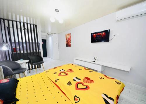 a yellow blanket on a bed in a room at Glamour in Năvodari