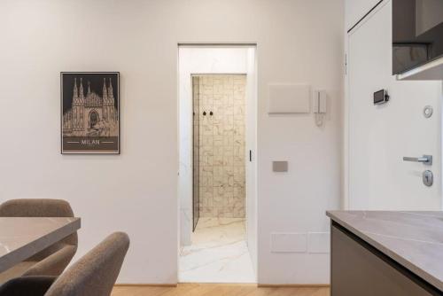 uma cozinha com paredes brancas e uma porta para um corredor em Da Carmine bilocale in Centrale em Milão
