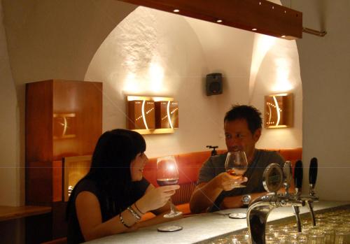 a man sitting at a bar drinking a glass of wine at Hotel Mondschein in Vipiteno