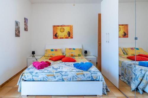 een slaapkamer met 2 bedden en kleurrijke kussens bij Villa Franca zona Arenella in Siracusa