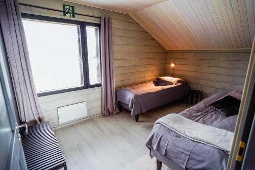 una camera con due letti in una stanza con finestra di Ruka Twin 3 bedroom Villa with Jacuzzi by Rukalodges a Ruka