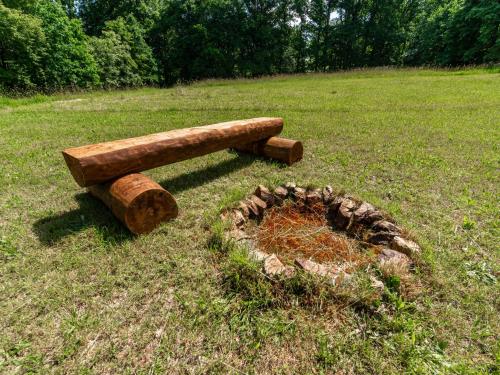 a wooden bench sitting in the grass with a hat at Holiday Home Bára 2 by Interhome in Stráž nad Nežárkou