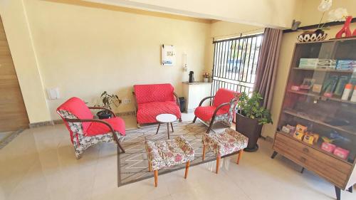 uma sala de estar com cadeiras vermelhas e uma mesa em Pousada Beth Shalom em Conceição da Barra