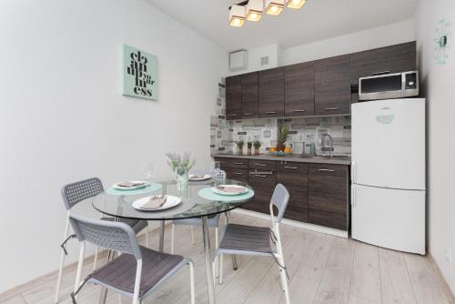 a kitchen with a table and chairs and a refrigerator at Turzycowa Apartment in Gdansk by Renters in Gdańsk