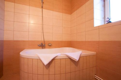 a bathroom with a bath tub with two towels at Filo Hotel in Gheorgheni