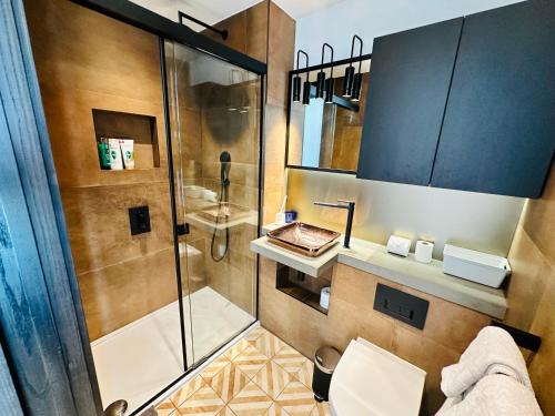 a bathroom with a shower and a toilet and a sink at Luxury Central Flat with Stunning Views and Pool in London