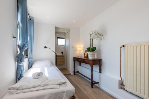 ein kleines Zimmer mit einem Bett und einem Tisch in der Unterkunft Welcome in - Vakantiehuis Oostburgsestraat 44, Zuidzande in Zuidzande