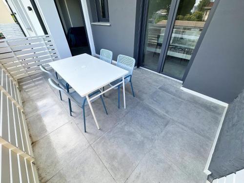 uma mesa branca e cadeiras numa varanda em LUX apartments em Follonica