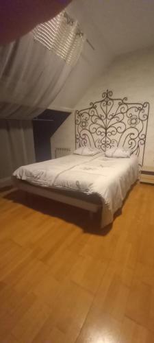Bett in einem Zimmer mit Holzboden in der Unterkunft Aline Pichereau in Channay-sur-Lathan