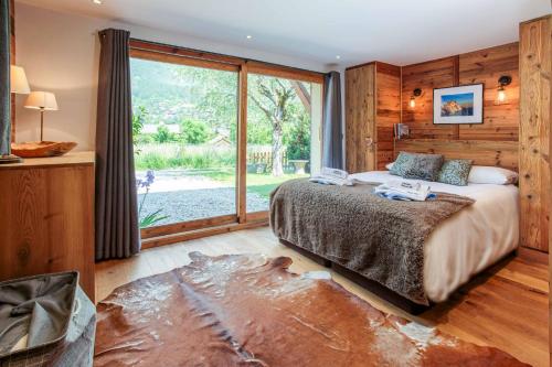 a bedroom with a bed and a large window at Chalet du Dard - Chamonix All Year in Chamonix-Mont-Blanc