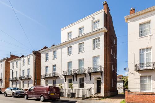 a white building on a street with cars parked in front at L-Spa Boutique Apartments in Leamington Spa