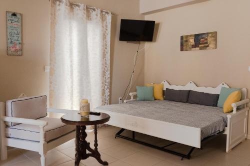 a bedroom with a bed and a chair and a television at John&Effie's Studio in Lygia