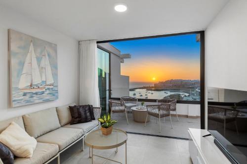 a living room with a couch and a large window at Palmera Sea View in Patalavaca