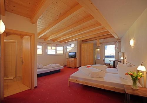 a large room with two beds and a television at Hotel Traube in Fliess