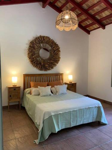 Casa de Piedra في لا كومبر: غرفة نوم بسرير كبير ومرآة على الحائط