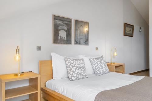 a bedroom with a bed with white sheets and two lamps at Casa Anaim by Homie in Lapeiras