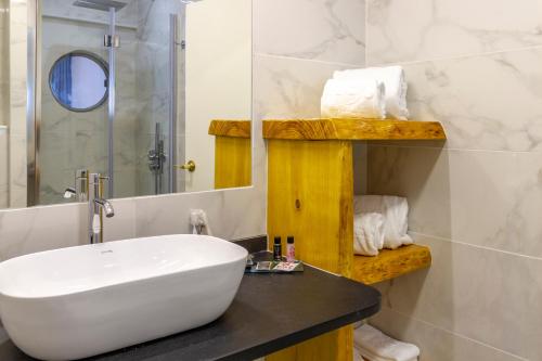 uma casa de banho com um lavatório branco e um espelho. em Hotel A.S. Lisboa em Lisboa