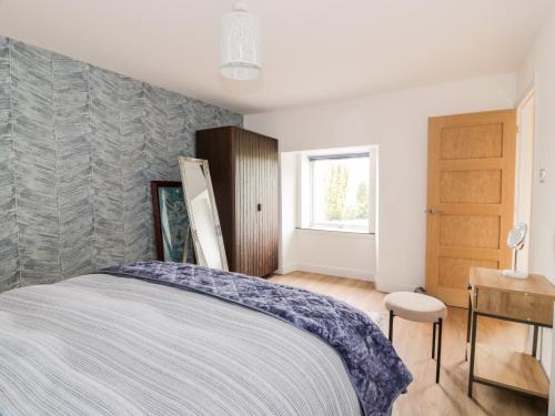 1 dormitorio con cama y ventana en Braeface Cottage, en Bonnybridge