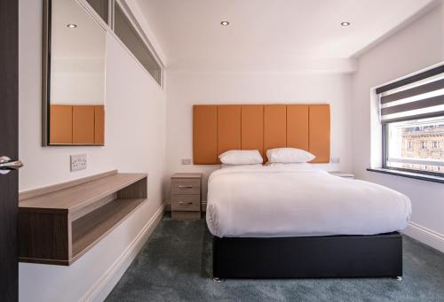 a bedroom with a large bed and a wooden headboard at The Castle Collection - 5 Union Court in Liverpool