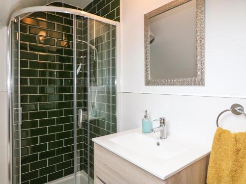 W łazience znajduje się umywalka i prysznic z zielonymi kafelkami. w obiekcie An Sean Teach w Killarney