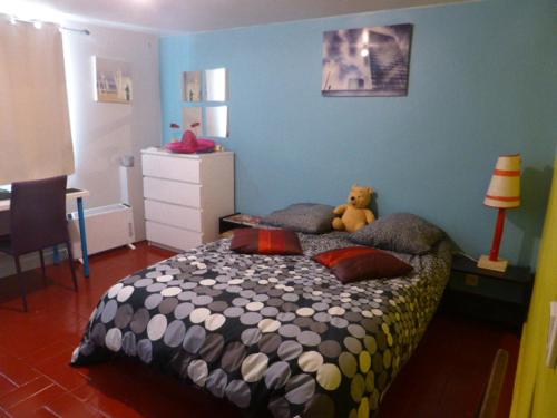 une chambre avec un lit avec un ours en peluche dessus dans l'établissement SUPERBE VILLA - MODERNE sur JARDIN 15 Mn de Paris, à Le Perreux-Sur-Marne