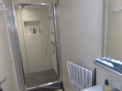een douche met een glazen deur in de badkamer bij SUPERBE VILLA - MODERNE sur JARDIN 15 Mn de Paris in Le Perreux-Sur-Marne