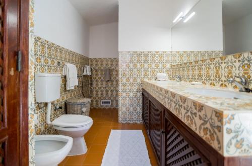 a bathroom with a toilet and a sink at Traditional 3 bedroom villa with great pool in the heart of Vale do Lobo in Vale do Lobo