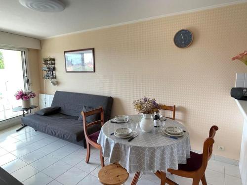 un salon avec une table et un canapé dans l'établissement - Le Montauban - Appartement avec grande terrasse, à La Chaume