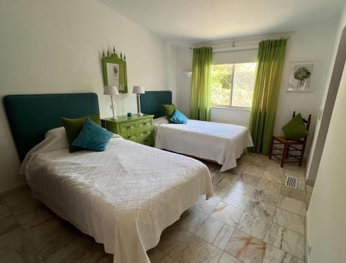 a bedroom with two beds and a window at Traditional 3 bedroom villa with great pool in the heart of Vale do Lobo in Vale do Lobo