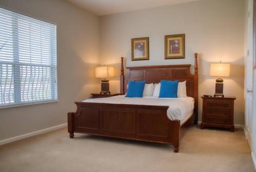 um quarto com uma cama grande e almofadas azuis em Vista Cay Luxury 3BR Condo em Orlando