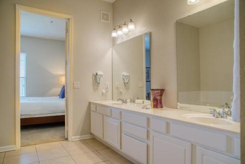 uma casa de banho com 2 lavatórios e um espelho grande em Vista Cay Luxury 3BR Condo em Orlando