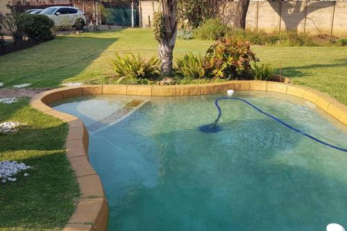 a swimming pool with a hose in a yard at Alberton Guest House in Alberton