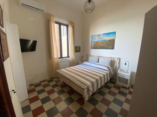 a bedroom with a bed and a checkered floor at AmMARE in Crotone