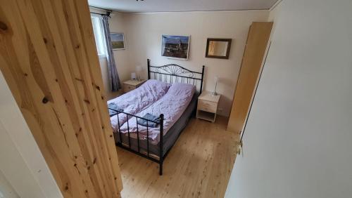 een slaapkamer met een bed en een houten vloer bij Flott leilighet i stille og rolig område, med gratis privat parkering! in Stavanger