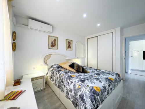 a white bedroom with a bed and a desk at Vivalidays Lora - Santa Susanna in Santa Susanna